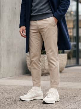 2002r – Beige tapered chinos worn with a charcoal grey cashmere turtleneck sweater and a long navy wool overcoat for a sophisticated casual look.