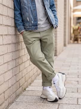 Relaxed-fit khaki chinos with a crisp white long-sleeve tee and a denim jacket for a classic, layered aesthetic.