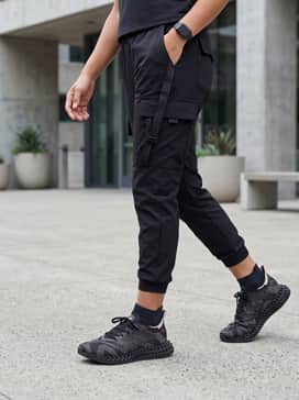 4dfwd 4 Shoes – Tapered black cargo joggers with a fitted black bodysuit and an oversized olive utility vest for a futuristic tech-wear aesthetic.