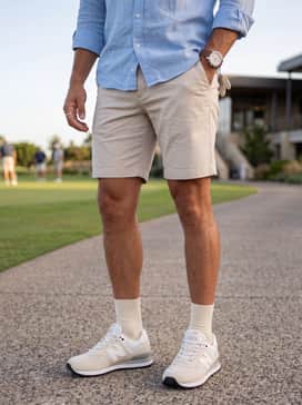 574 Greens V2 – Clubhouse Casual: Match with tailored beige shorts, a light blue linen button-down shirt with rolled sleeves, and a premium leather-strap watch for a relaxed post-game vibe.