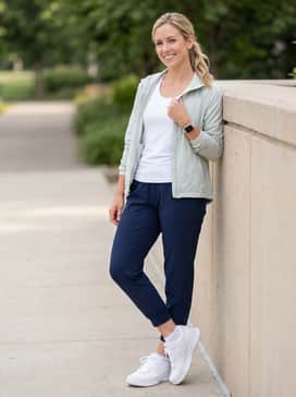 577v1 – Navy blue tapered joggers with a tucked-in white tank top and a lightweight pastel windbreaker for morning walks.