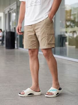 Style with loose-fitting khaki cargo shorts and a boxy white graphic tee for a contemporary street-ready look.