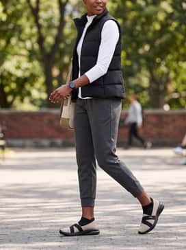 Adelina 2 Topcat Womens Slipon Shoes – Tapered charcoal joggers with a fitted white mock-neck top and a black puffer vest for a sporty weekend look.