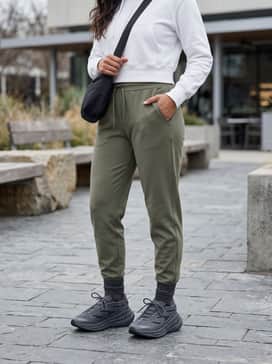 A chic athleisure ensemble with high-waisted olive green joggers, a white cropped hoodie, and a sleek black crossbody bag for a smooth transition from gym to brunch.