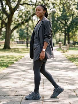 Adidas By Stella Mccartney Adistar – An effortless urban outfit consisting of black bike shorts, a structural oversized beige blazer, and a simple charcoal sports bra for a modern tonal aesthetic.