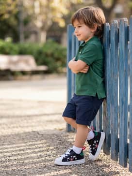 Classic navy chino shorts paired with a forest green polo shirt to subtly draw out the green detailing on the sneaker's heel.