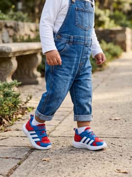 Adidas Marvel Lightorama Spiderman Shoes Infants – Classic denim overalls worn over a plain white long-sleeve tee, letting the bright red and blue shoes be the statement pop of color.