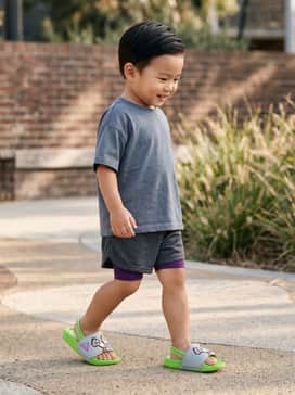 A lime green graphic t-shirt featuring Buzz Lightyear paired with charcoal grey mesh athletic shorts for a coordinated and sporty playground look.