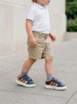 Classic khaki chino shorts and a simple white polo shirt for a clean, 'smart-casual' aesthetic that remains comfortable for all-day wear.