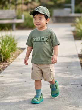 Adidas X Minecraft Adifom Adilette Slides Kids – A Minecraft-themed graphic t-shirt paired with olive green cargo shorts and a matching pixel-patterned baseball cap for a thematic summer look.