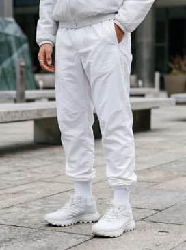 Adidas X Moon Boot Padded Tracktop – Pair with slim-fit charcoal utility joggers and an oversized black puffer vest to emphasize the boot's bold and chunky silhouette.