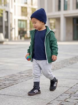 A sporty playground look featuring gray cotton joggers, a navy blue graphic t-shirt, and a lightweight windbreaker jacket.