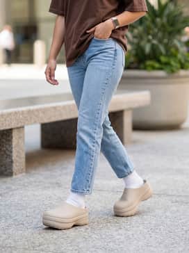 Adifom Stan Smith Mule Shoes – Oversized vintage graphic hoodie in a chocolate brown shade with black biker shorts and white crew socks for a trendy athletic aesthetic.