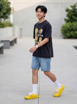 Adilette Clog  Simpson – An oversized graphic tee featuring vintage cartoons paired with baggy blue denim shorts and tall white crew socks.