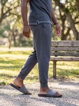 Tapered grey joggers and a technical fabric polo shirt in a matching team color for a sleek, post-workout recovery outfit.