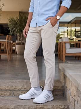 Adipower 26 Spikeless Golf Shoes – Slim-fit stone-colored chinos paired with a light blue linen button-down shirt for a sophisticated post-round clubhouse lunch.