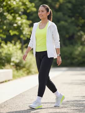 Adistar 4 Running Shoes – A high-performance running outfit featuring black compression leggings, a neon yellow moisture-wicking racerback tank to match the shoe accents, and a lightweight white windbreaker.