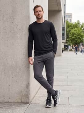 Straight-leg indigo jeans cuffed at the bottom, a crisp white crewneck t-shirt, and a grey bomber jacket for a clean, elevated casual weekend outfit.