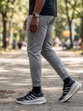 Heather grey joggers with a slim fit, a black quarter-zip performance fleece, and a metallic-finish sports watch to complement the shoe's silver stripes.