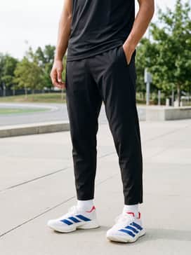 A sleek training ensemble consisting of black compression tights, a form-fitting royal blue quarter-zip pullover, and a moisture-wicking white running cap.