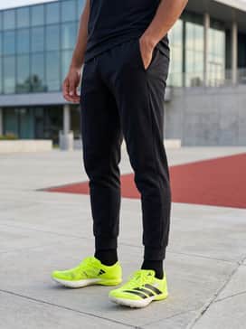A pre-race warm-up ensemble consisting of a lightweight black windbreaker, tapered tech-fleece joggers, and a breathable headband.