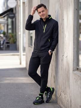 Adizero Aruku Shoes – A high-contrast athletic style featuring black compression leggings, a neon-accented windbreaker, and a silver-toned sports watch.
