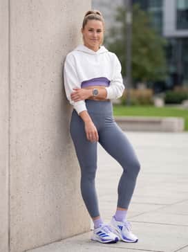 Adizero Boston 12 Shoes – High-waisted slate grey athletic tights combined with a cropped oversized white hoodie and a matching purple sports bra for a post-run recovery look.