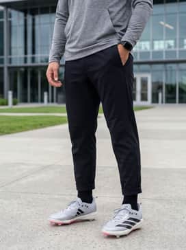 Adizero Electric 20 Cleats – A pre-game warmup look with tapered black joggers, a breathable tech-fabric hoodie, and a performance headband.