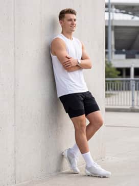 Adizero Electric Ii Football Cleats – Black athletic shorts with integrated compression layers and a white sleeveless tech tee to highlight the metallic silver stripes during speed training.