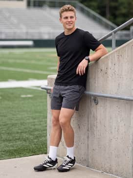 Adizero Electric Ii Rodeo American Football Cleats – Breathable mesh athletic shorts in charcoal grey worn with a sleek black compression long-sleeve top to emphasize a streamlined, high-speed aesthetic.