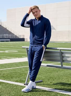 A matching navy blue and white team warmup tracksuit with white mid-calf athletic socks to maintain a cohesive sideline appearance.