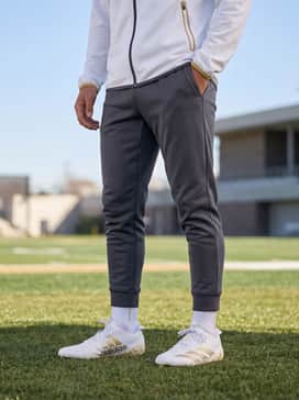Adizero Electric Ii Smu Football Cleats – A white moisture-wicking technical training shirt paired with charcoal grey tapered athletic joggers and gold-trimmed wristbands for a coordinated practice look.