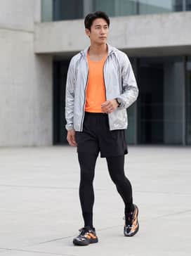 Adizero Evo Sl Exo – A pair of black compression running tights, a breathable neon orange racing singlet, and a lightweight silver metallic windbreaker for a cohesive professional track look.