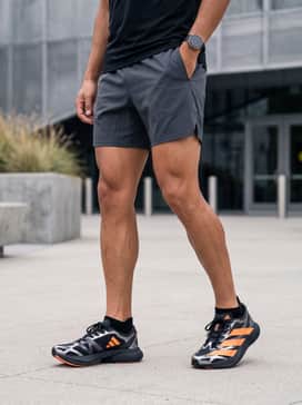 Charcoal grey 5-inch inseam athletic shorts, a black moisture-wicking performance t-shirt, and matching black low-cut socks to keep the focus on the shoes.
