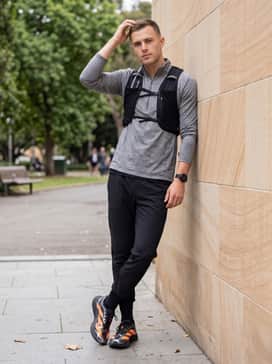 Adizero Evo Sl Exo – Tapered technical joggers in matte black, a grey marl quarter-zip pullover, and a sleek hydration vest for a functional long-distance training outfit.