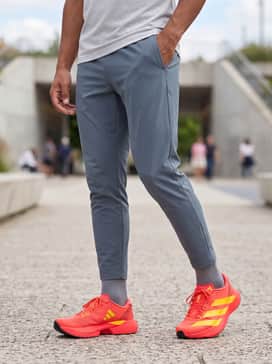Adizero Evo Sl – Tapered slate grey performance joggers matched with a bright electric yellow breathable mesh tank top to highlight the shoe's vibrant stripes.