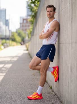 Adizero Evo Sl – Pro-level navy blue split running shorts and a white technical racing singlet featuring minimal red graphics for a classic track aesthetic.