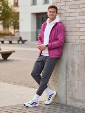 Adizero Evo Sl Shoes – A stylish post-run recovery outfit consisting of tapered charcoal grey joggers, a crisp white oversized hoodie, and a lightweight nylon windbreaker in a matching fuchsia accent.