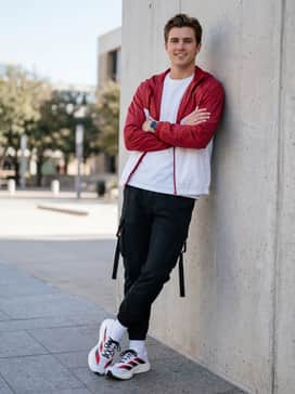 Street Tech: Tapered black cargo pants with utility straps, a white oversized graphic tee, and a lightweight nylon windbreaker in red.