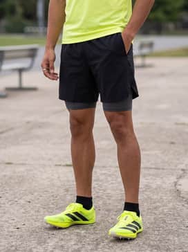A moisture-wicking neon yellow technical tee paired with lightweight black split running shorts for high-intensity training sessions.