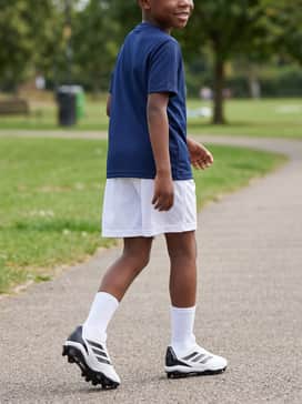 A school physical education kit with a breathable navy blue training tee, white athletic shorts, and performance-ready crew socks.