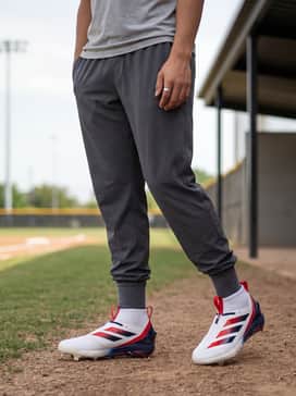 Adizero Impact 20 Usa Baseball Cleats – A modern athletic training look featuring charcoal gray tapered joggers, a navy moisture-wicking compression shirt, and a white performance headband.