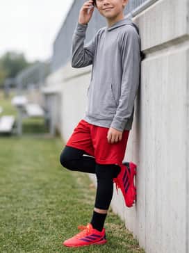 Adizero Impact Molded Rubber Kids 20 Shades Bsb Shoes – Black athletic compression tights worn under red mesh practice shorts with a lightweight grey performance hoodie for early morning warm-ups.