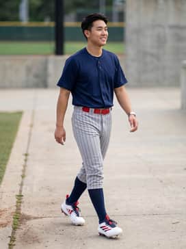 Adizero Impact Tpu 20 Usa Cleats – A professional baseball uniform featuring grey pinstriped pants, a navy blue jersey, and a coordinating red belt to mirror the shoe's accent colors.