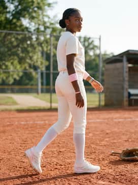 An all-white team uniform with silver accents and pink wristbands to make the glittery stripes on the cleats the centerpiece of the outfit.