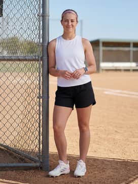 Adizero Instinct Tpu 20 Shoes – Black athletic sliding shorts and a breathable white team tank top, completed with a pink headband for a coordinated practice outfit.