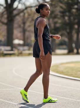 Adizero Sprintstar Shoes – A moisture-wicking graphic performance tank top in a neutral shade paired with relaxed-fit athletic shorts for comfort between race heats.