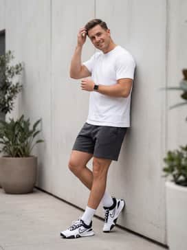 Charcoal grey fleece tech shorts combined with a crisp white heavyweight cotton t-shirt and athletic crew socks for a clean, gym-ready aesthetic.
