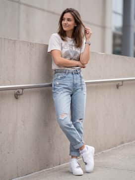 Light-wash distressed boyfriend jeans with a tucked-in vintage graphic tee and a silver chain belt that echoes the shoe's hardware.
