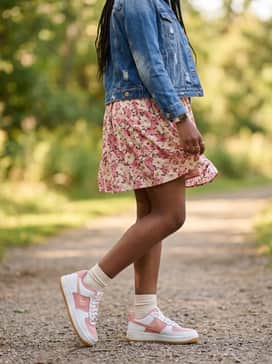 A floral print sundress in shades of pink and cream, topped with a distressed denim jacket for a perfect balance of feminine and edgy streetwear.